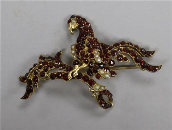 A garnet and split pearl set drop brooch, modelled as a parrot on a branch, 62mm.